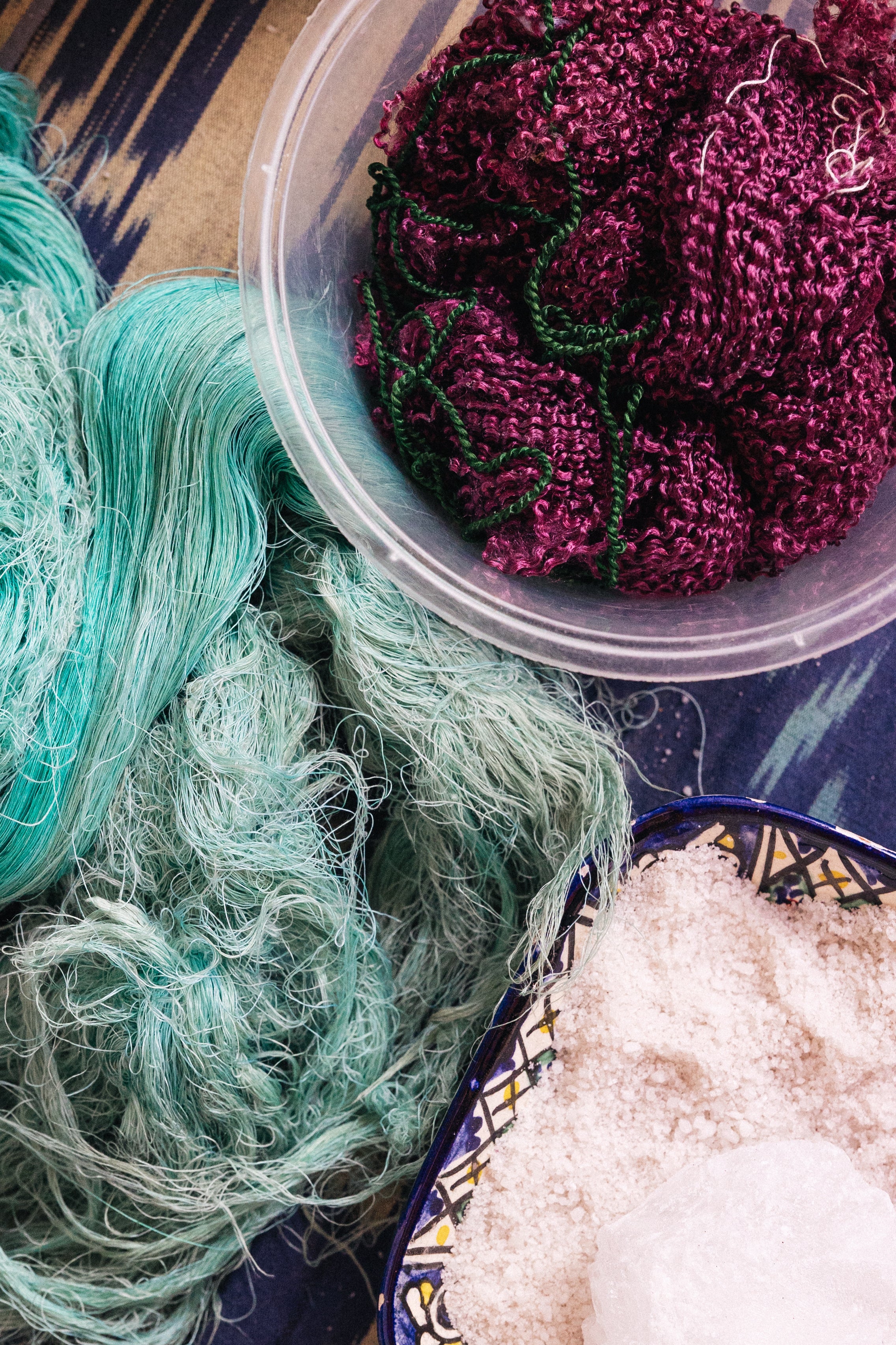 Green yarn, purple knitted items, and salt in making silk ikat - heritage in textiles - sustainability - Frankitas
