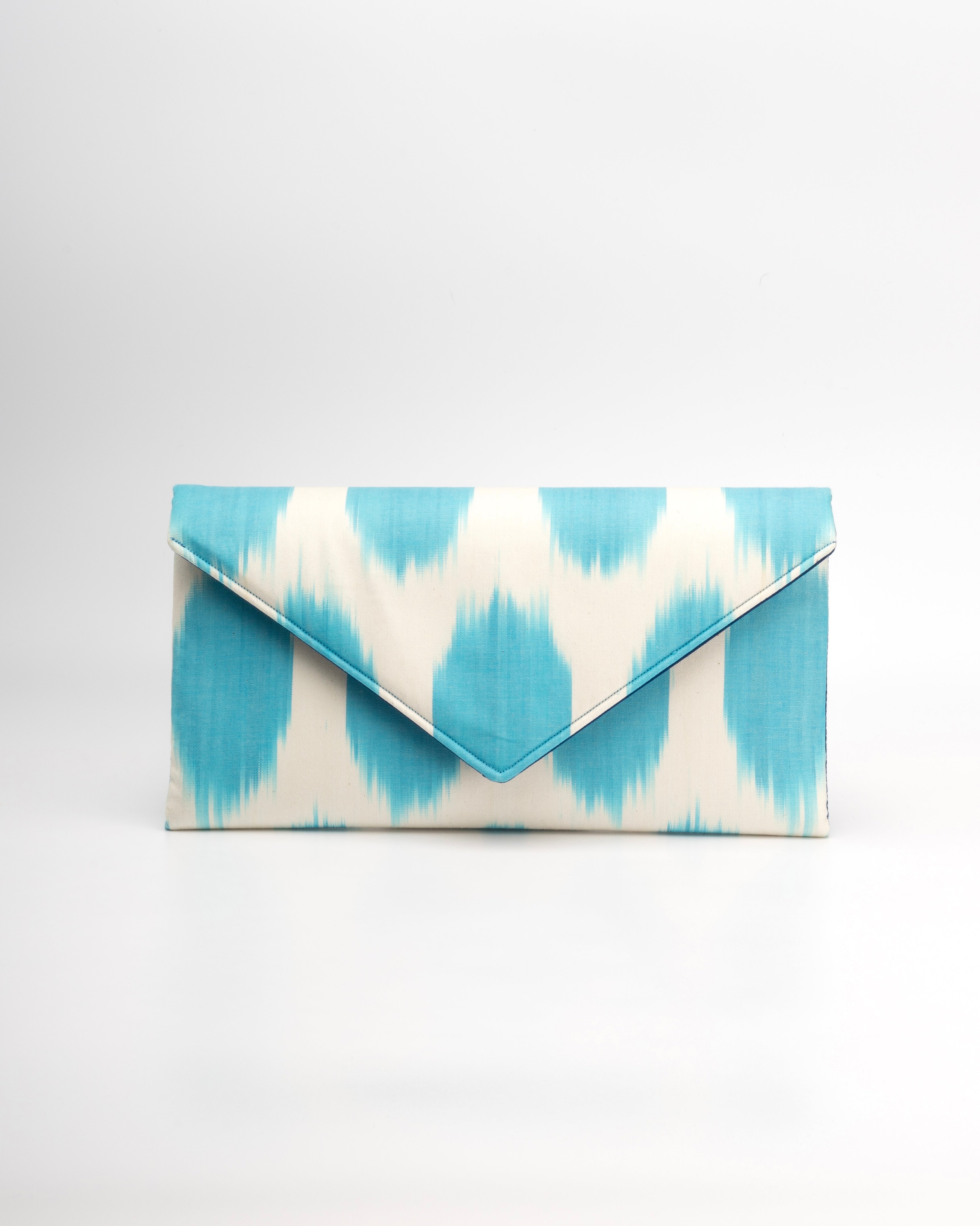 Showcasing exquisite handwoven silk ikat, Frankitas' classic envelope clutch The Titin -  is a perfect blend of heritage and fashion in a light blue and white polka dot