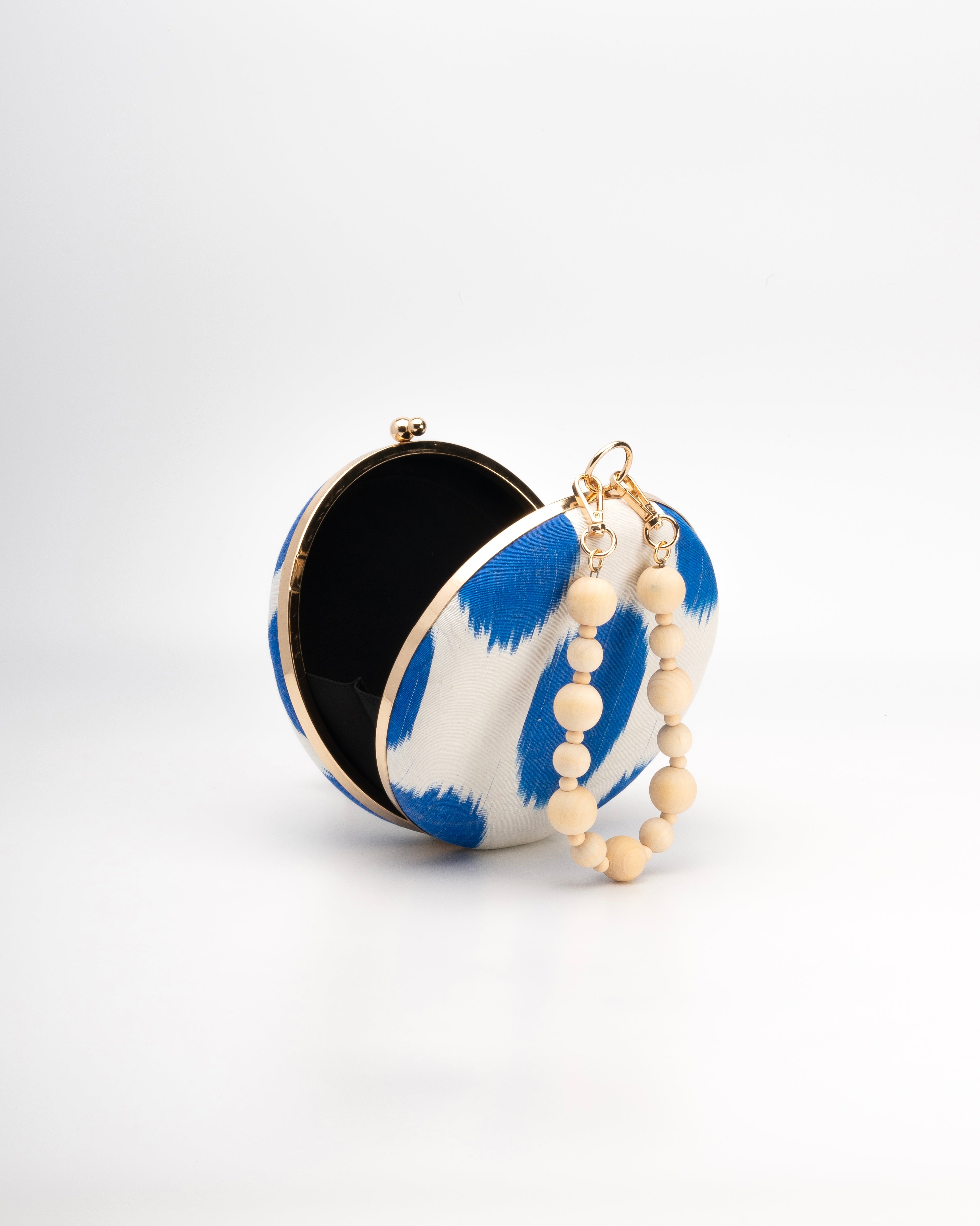 Deep blue and white patterned polka dot Frankitas clutch with royal blue silk Ikat pattern and a natural wooden beaded strap