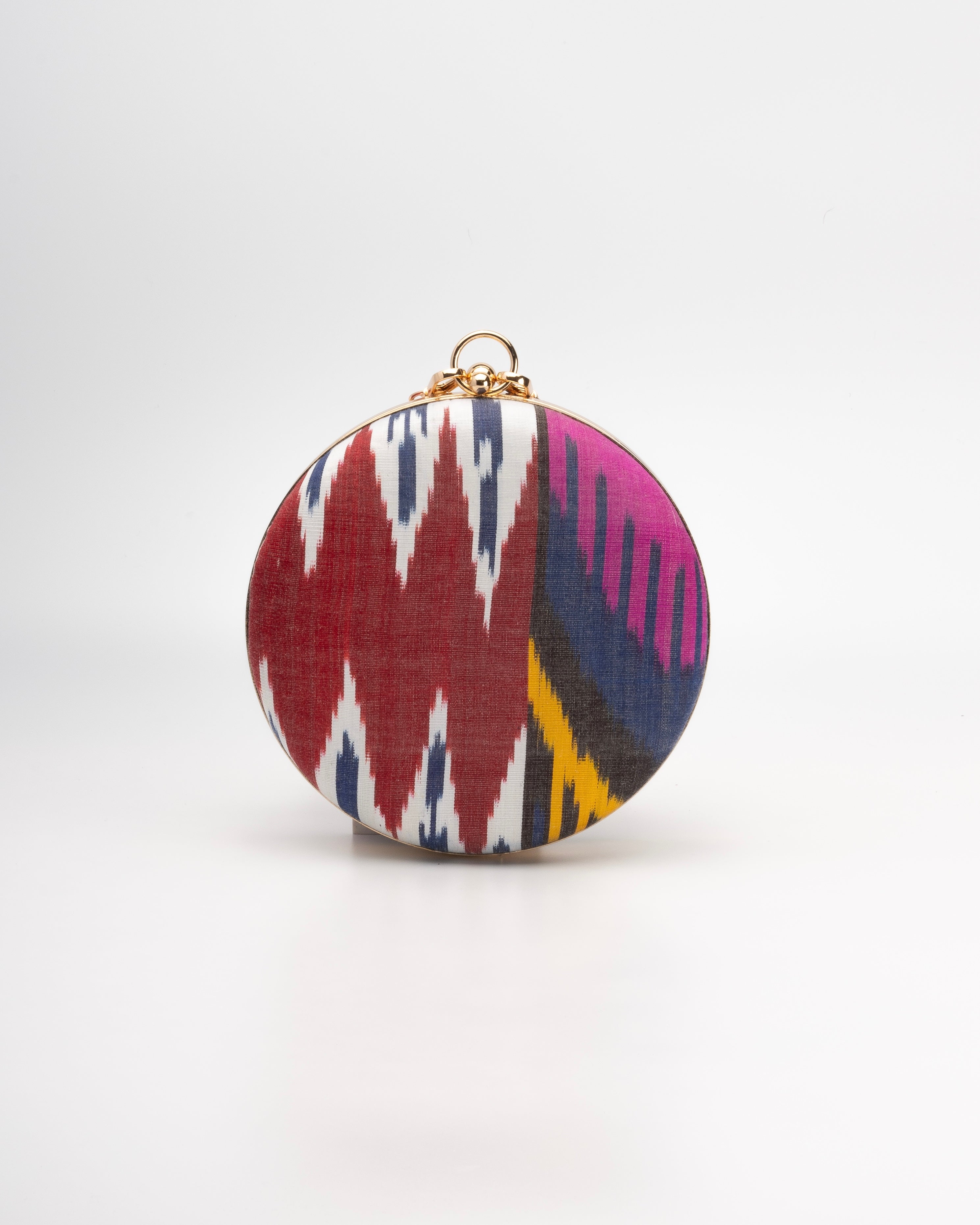 Frankitas round Puteri clutch bag, handcrafted with vibrant handwoven silk Ikat and embodying a modern twist on traditional Asian heritage.
