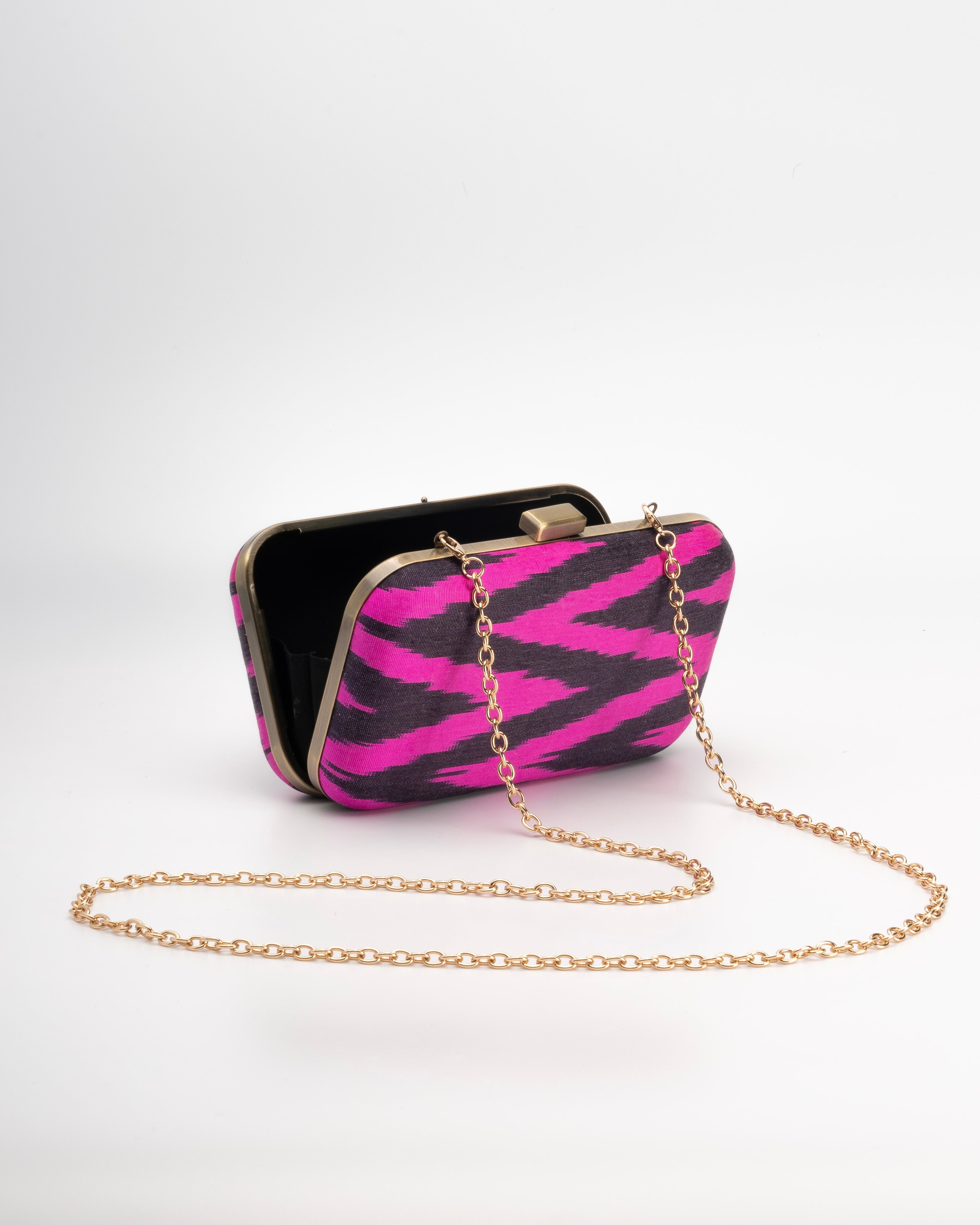 Frankitas Tasia box clutch bag with fuchsia pink and black zebra pattern with a long gold metal strap