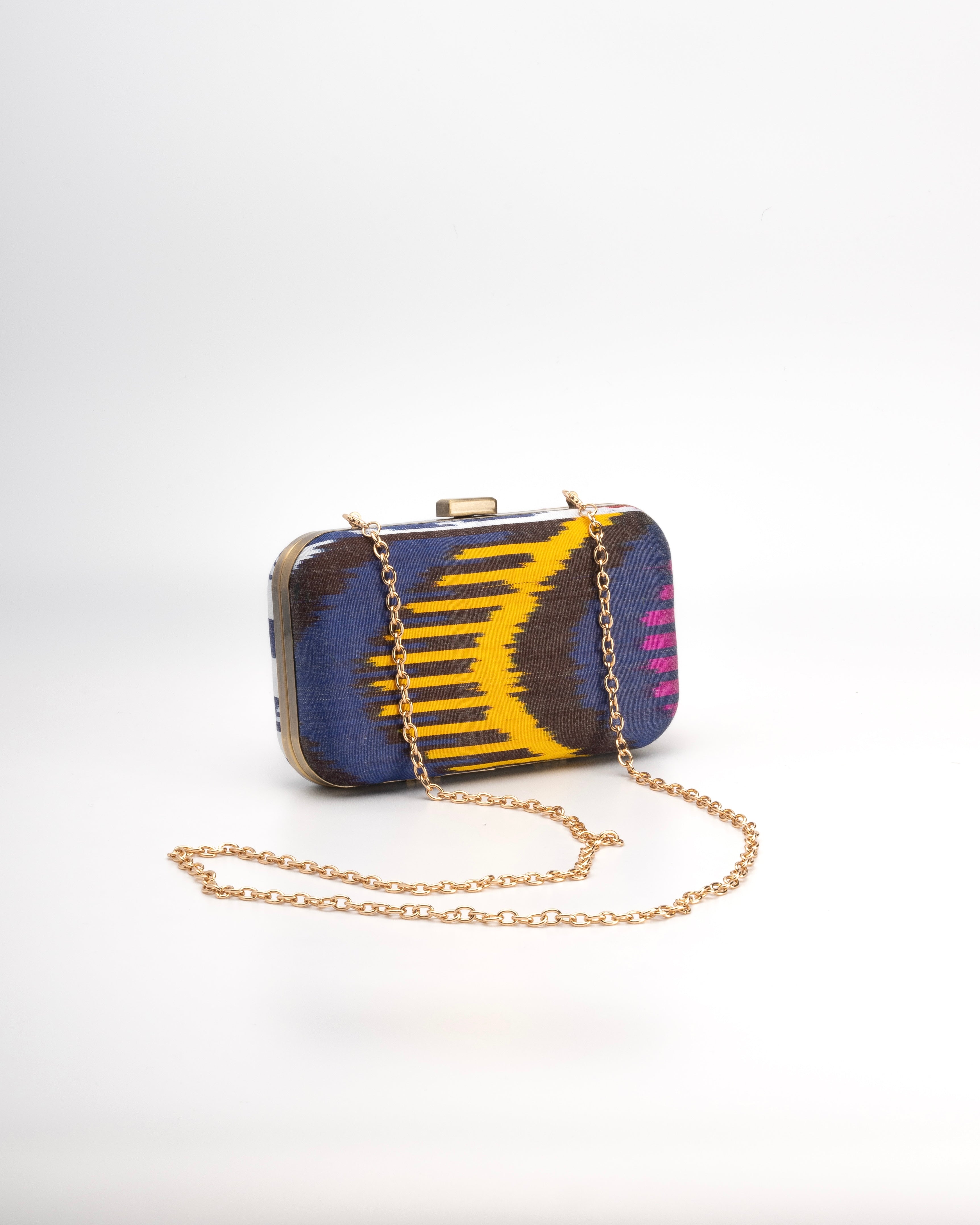 Frankitas colorful clutch bag with a chain strap on a white background