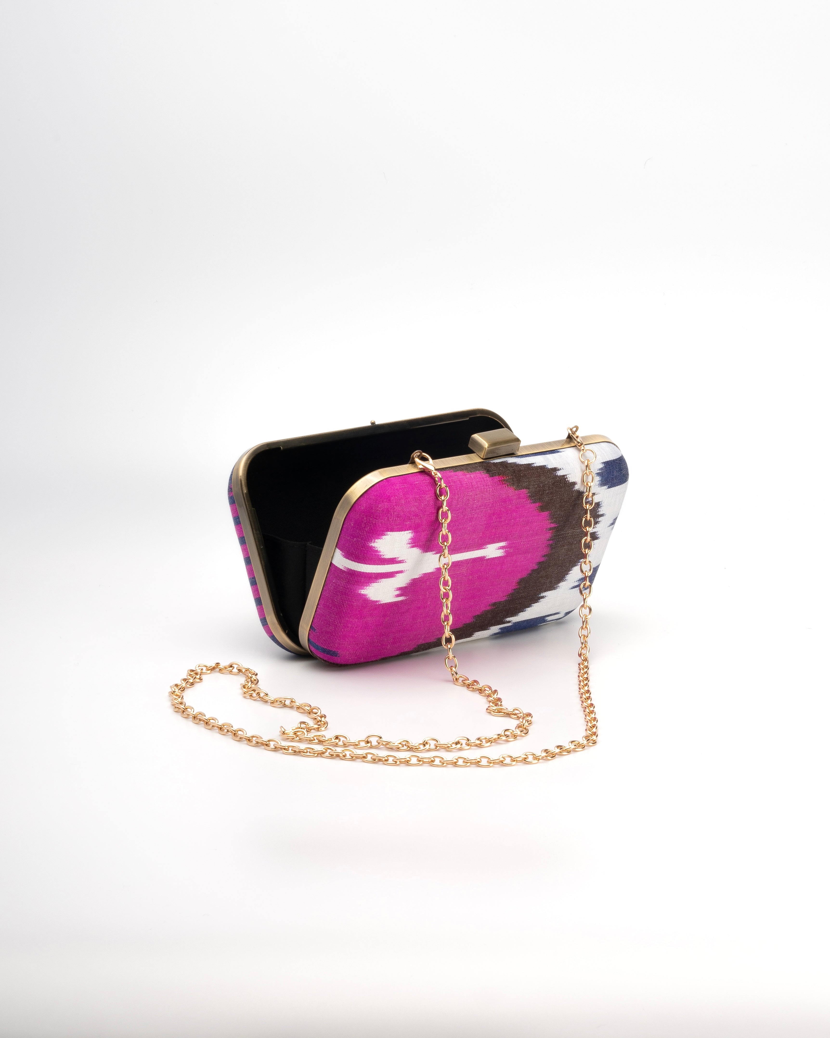 This elegant handwoven silk Ikat clutch by Frankitas blends pink, white, blue, and black hues for a standout accessory with a metal gold strap