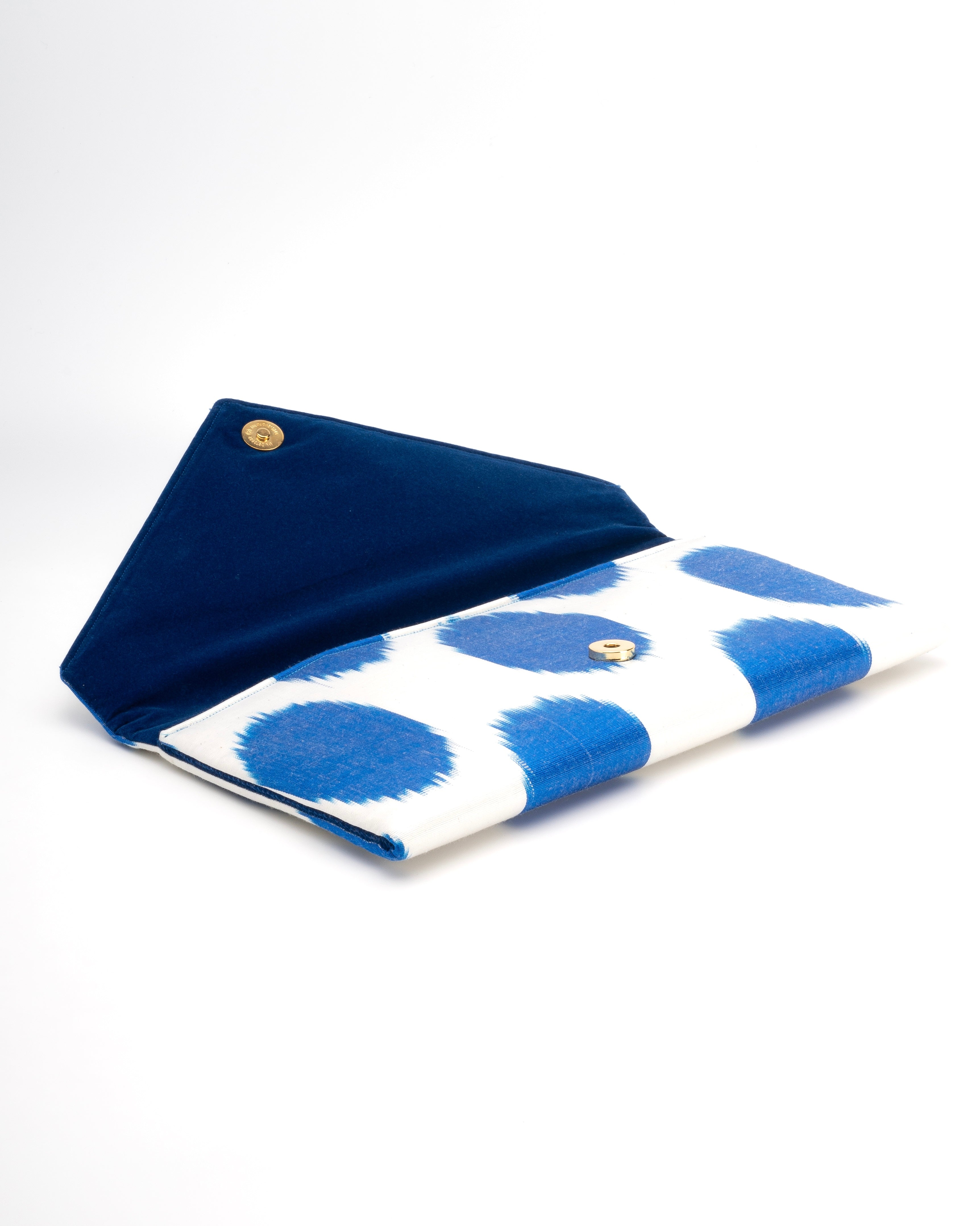 Artisanal envelope clutch blending hand‑loomed Central Asian Ikat with classic polka‑dot style in deep blue and white