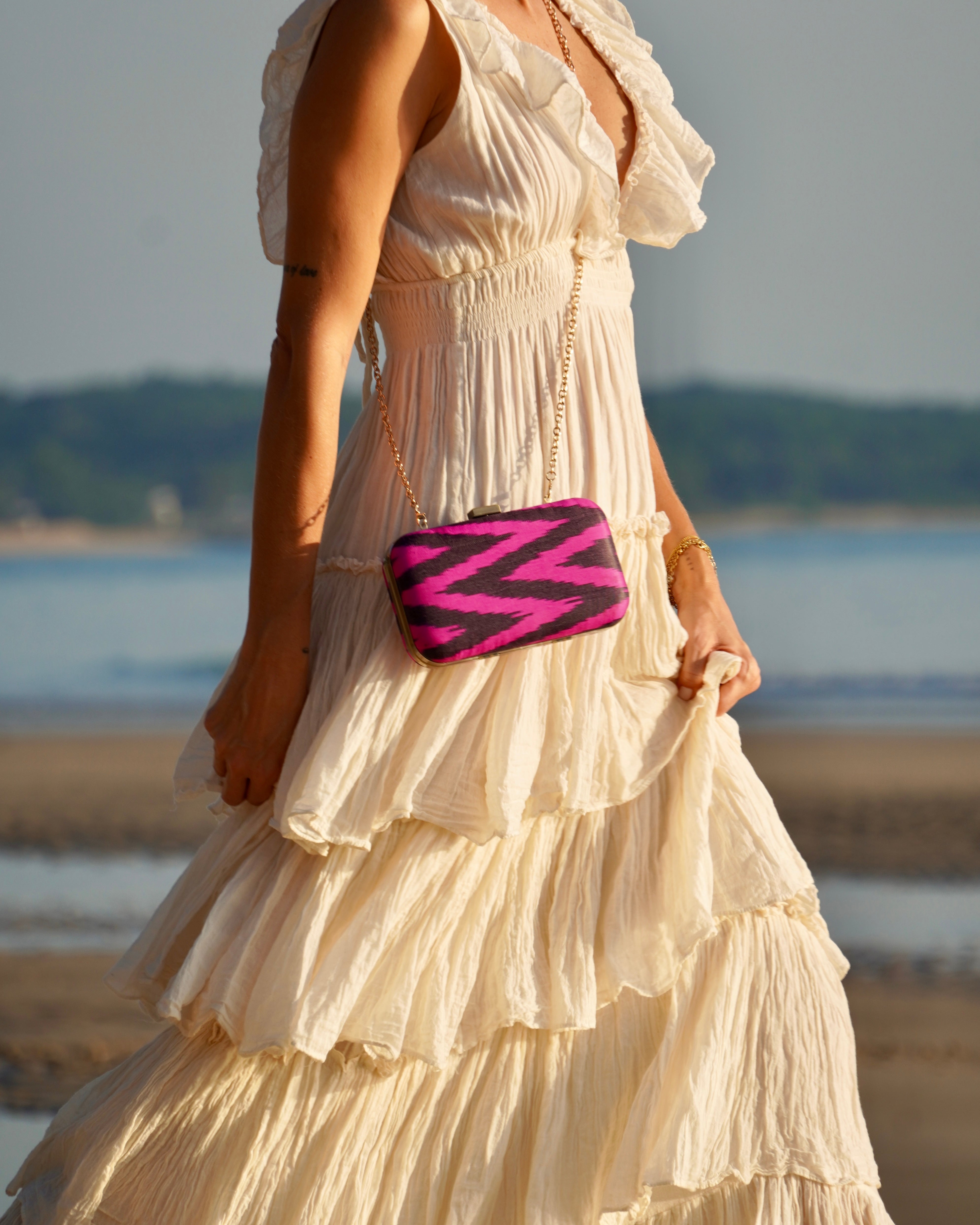 Fuchsia and black chevron Ikat fabric on a handcrafted Frankitas Tasia clutch, blending heritage and modernity