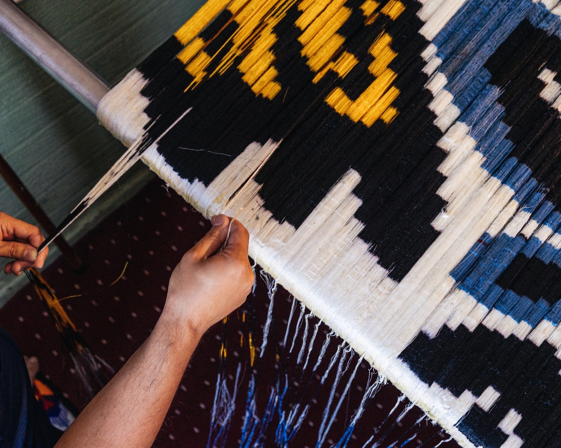 Artisan weaving on a loom Silk Ikat with colorful patterns