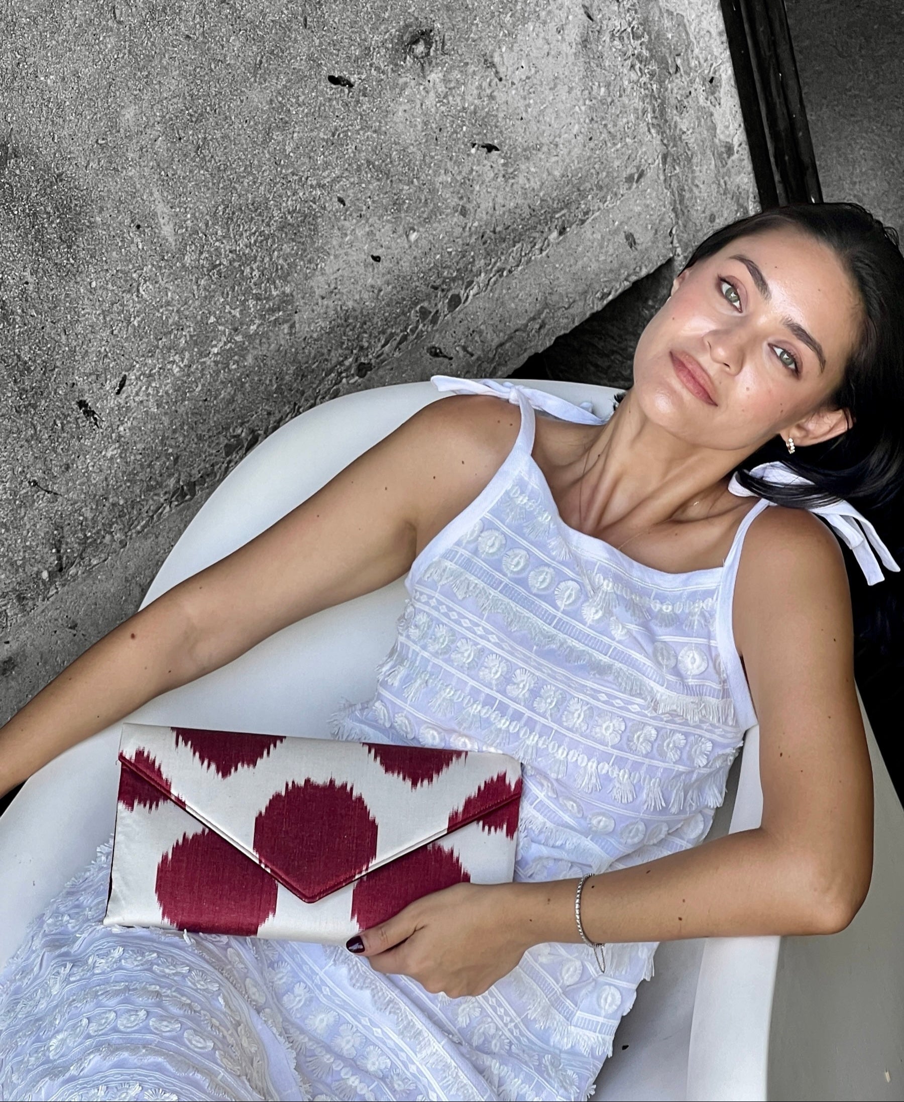 Woman holding a red and white polka dot Frankitas clutch bag